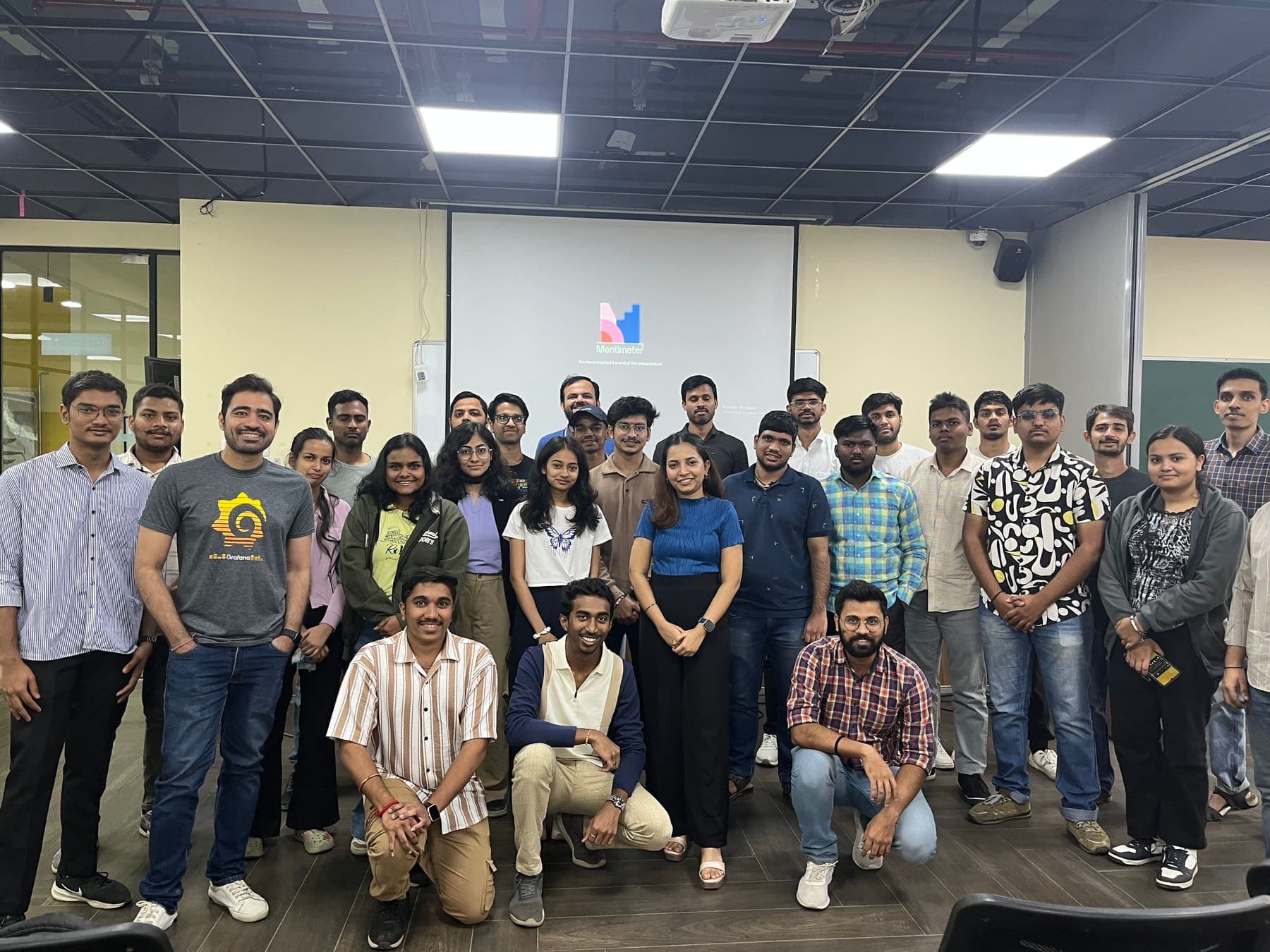 A meetup crowd in Grafana tees. The group photo after the talks and the Mentimeter quiz.